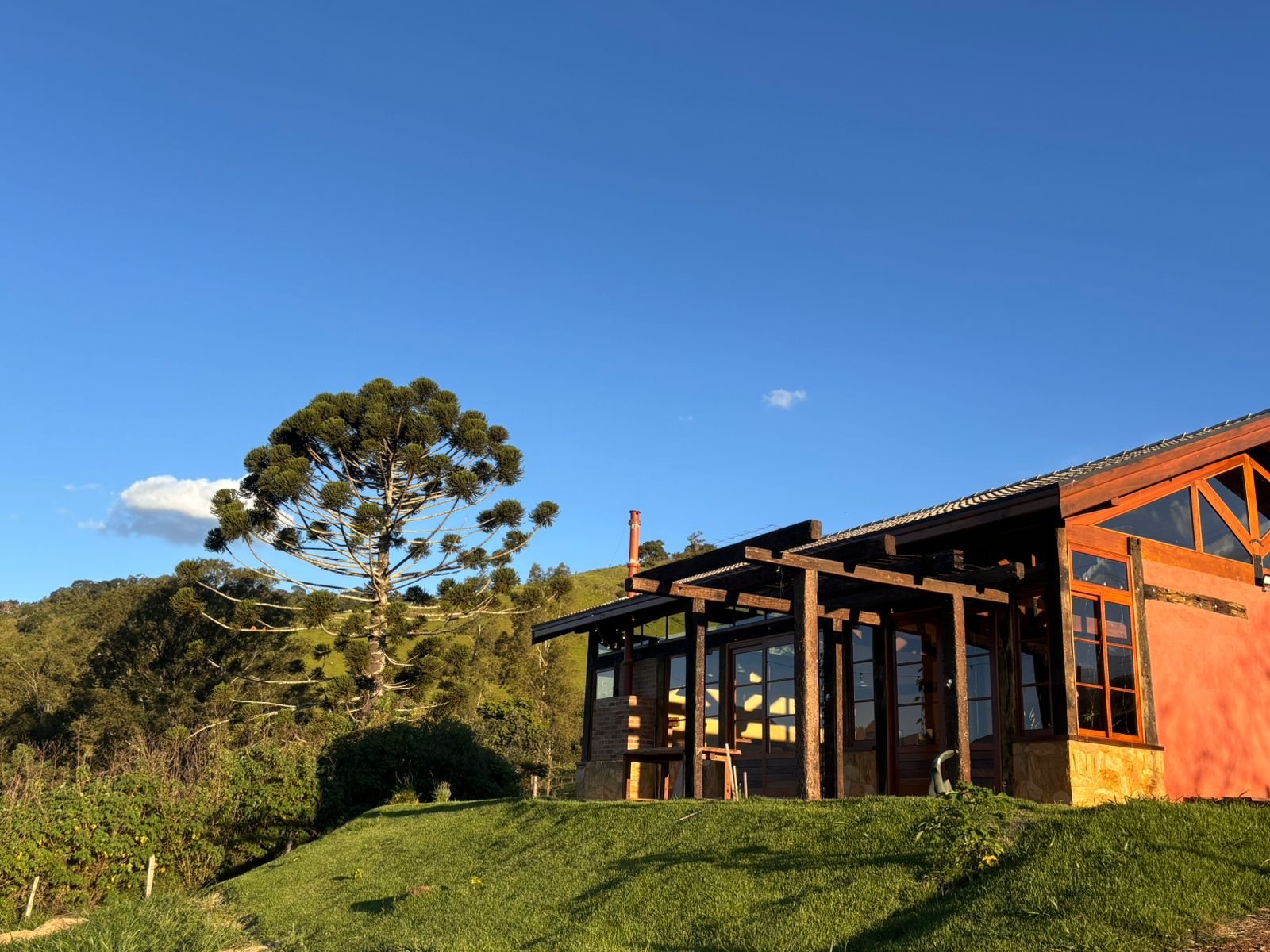 Fachada da Morada Canto do Sol entre araucárias