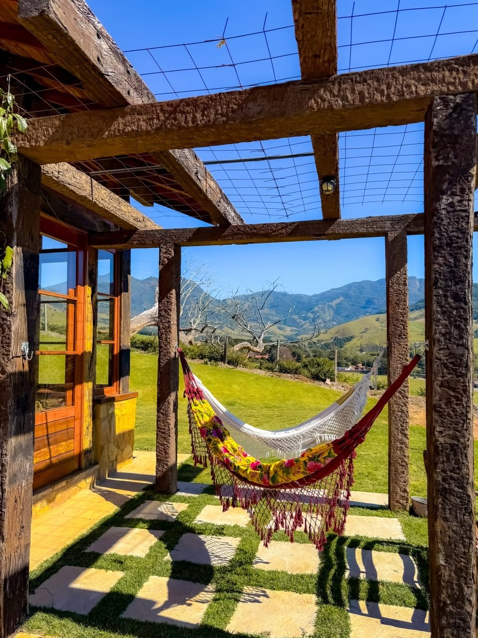 Redes sob o pergolado da Morada Canto do Sol, com a serra ao fundo
