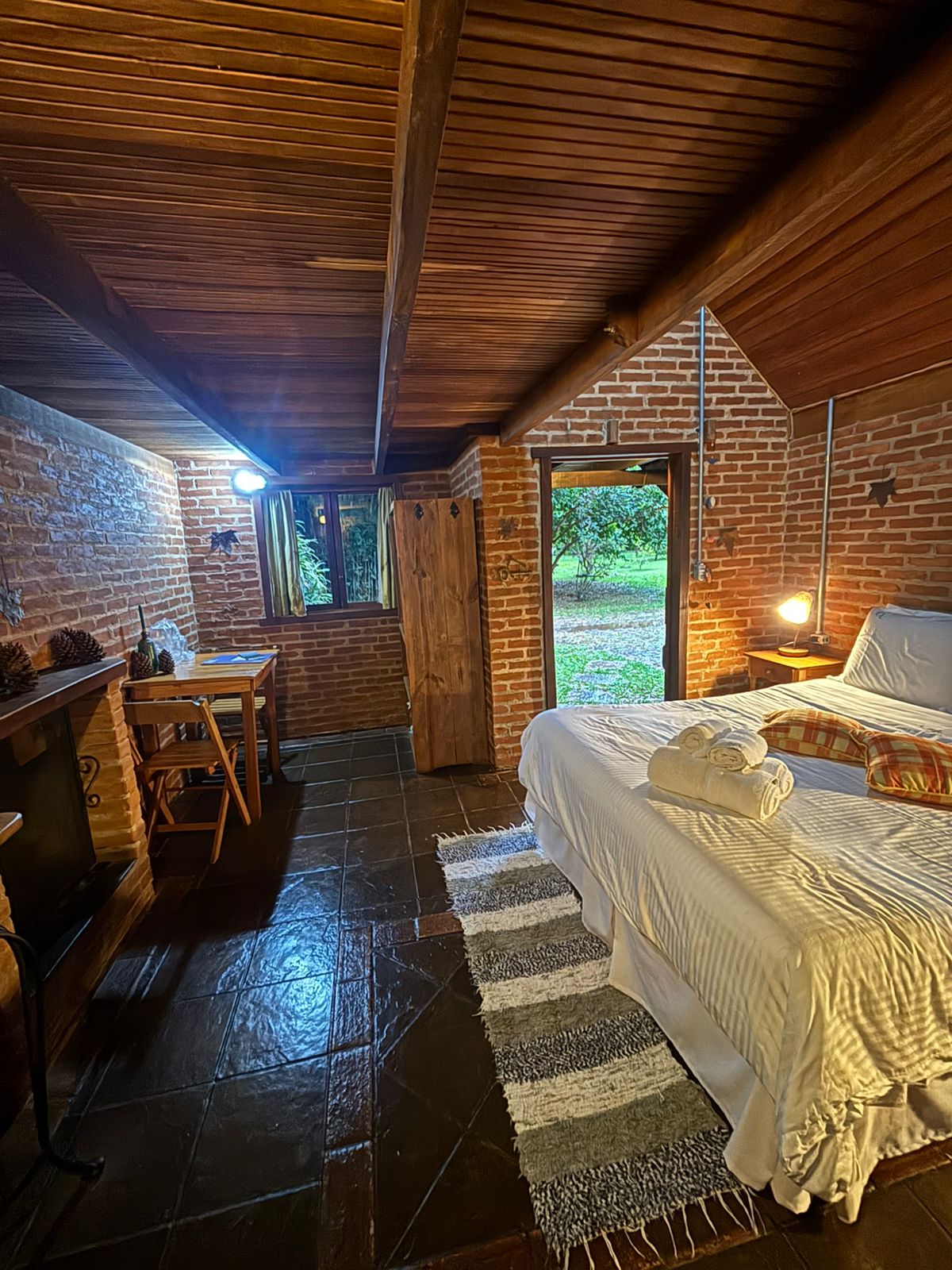 Quarto do Araucária com a porta aberta para o verde