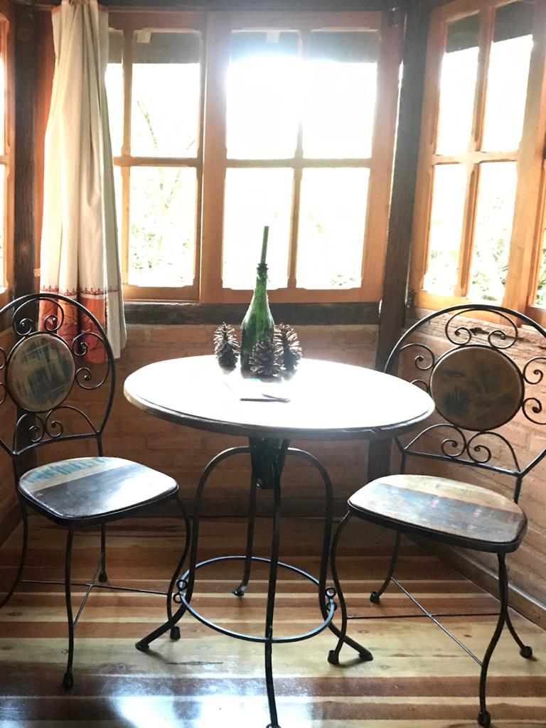 Mesa de ferro e cadeiras diante da janela iluminada