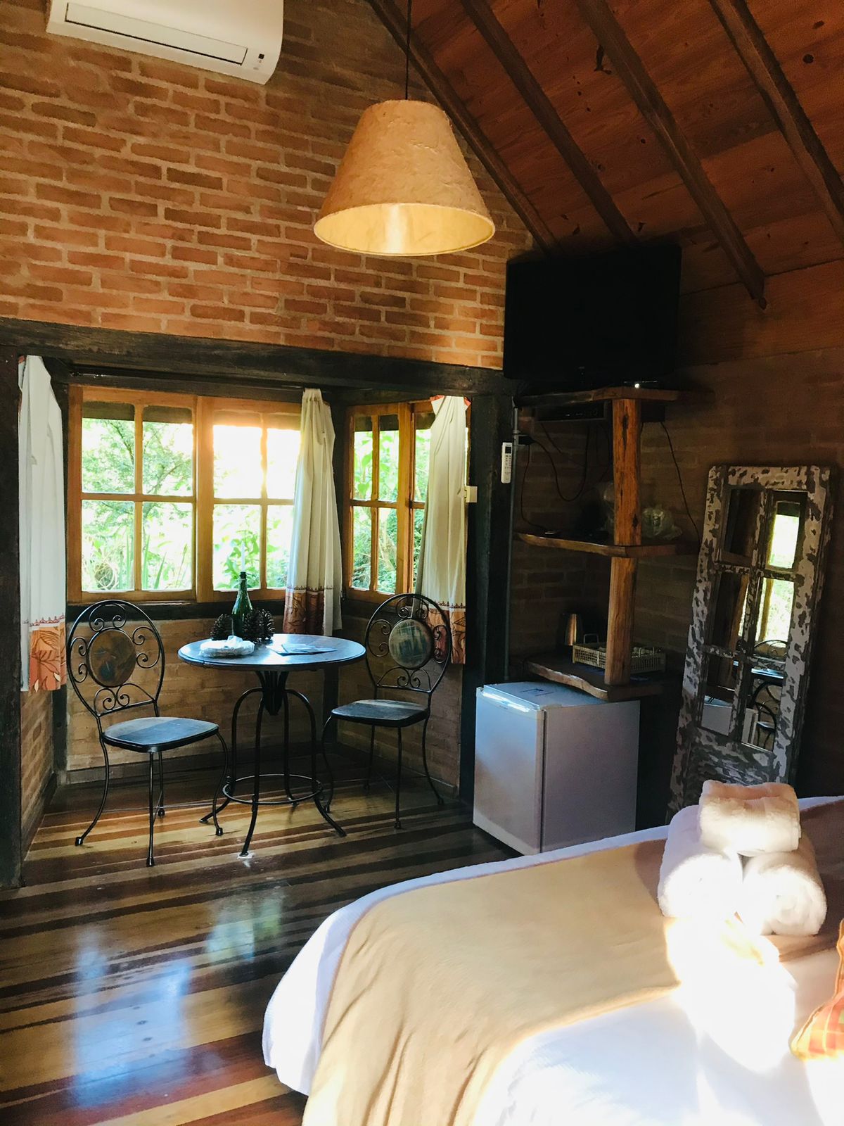 Mesa de ferro junto à janela, TV e espelho de janela antiga