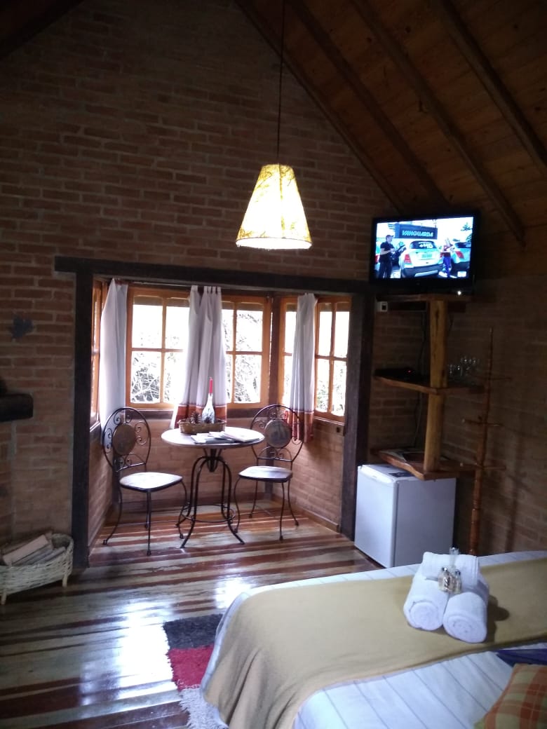 Mesa de ferro, TV e frigobar do Manacá