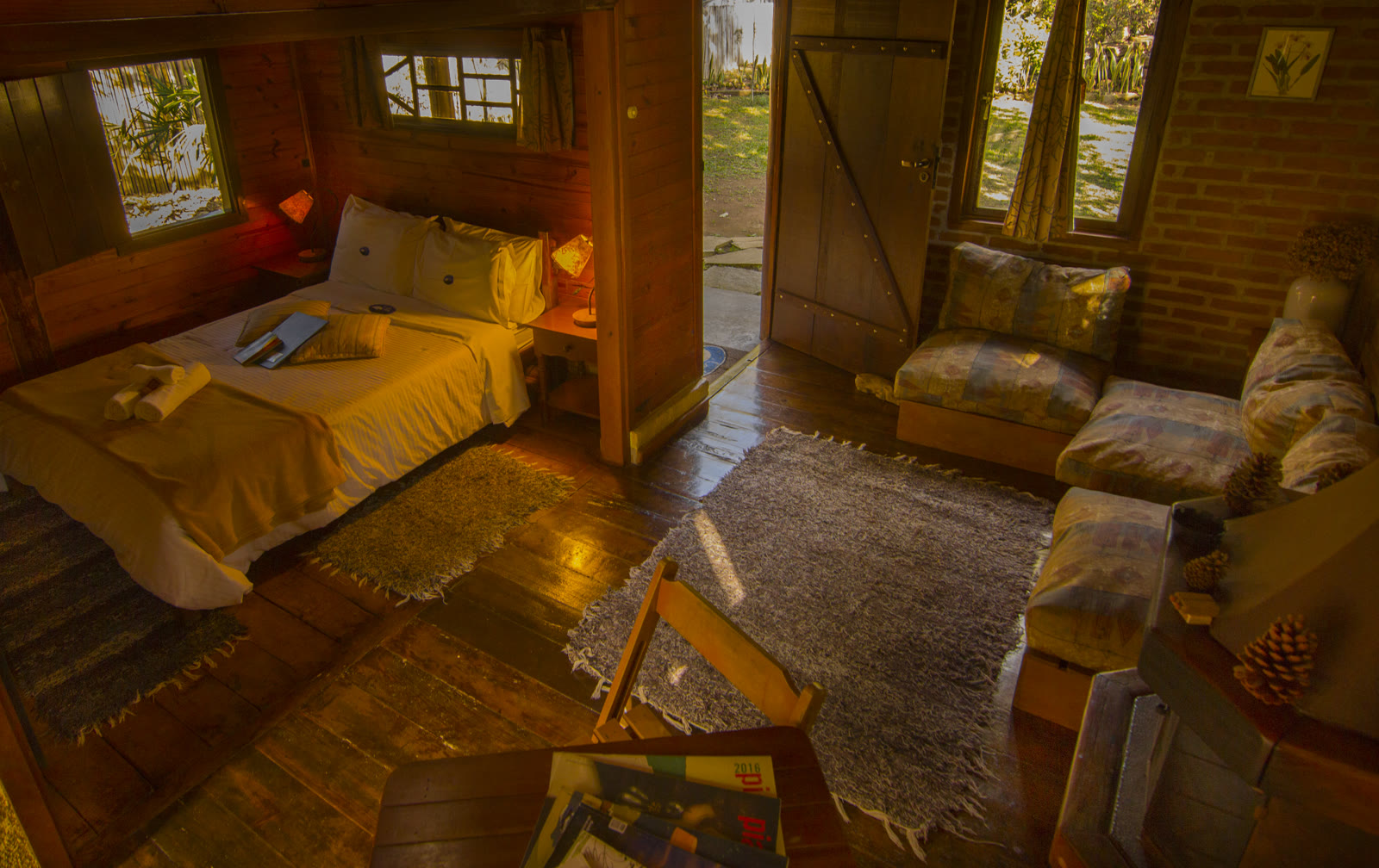 Interior do Paineiras visto de cima, com a cama, a porta aberta e o sofá