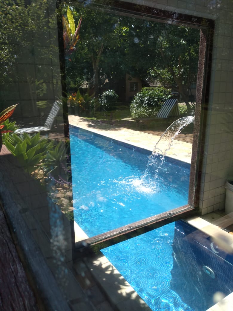 Vista da piscina e do jardim através do vidro da sauna